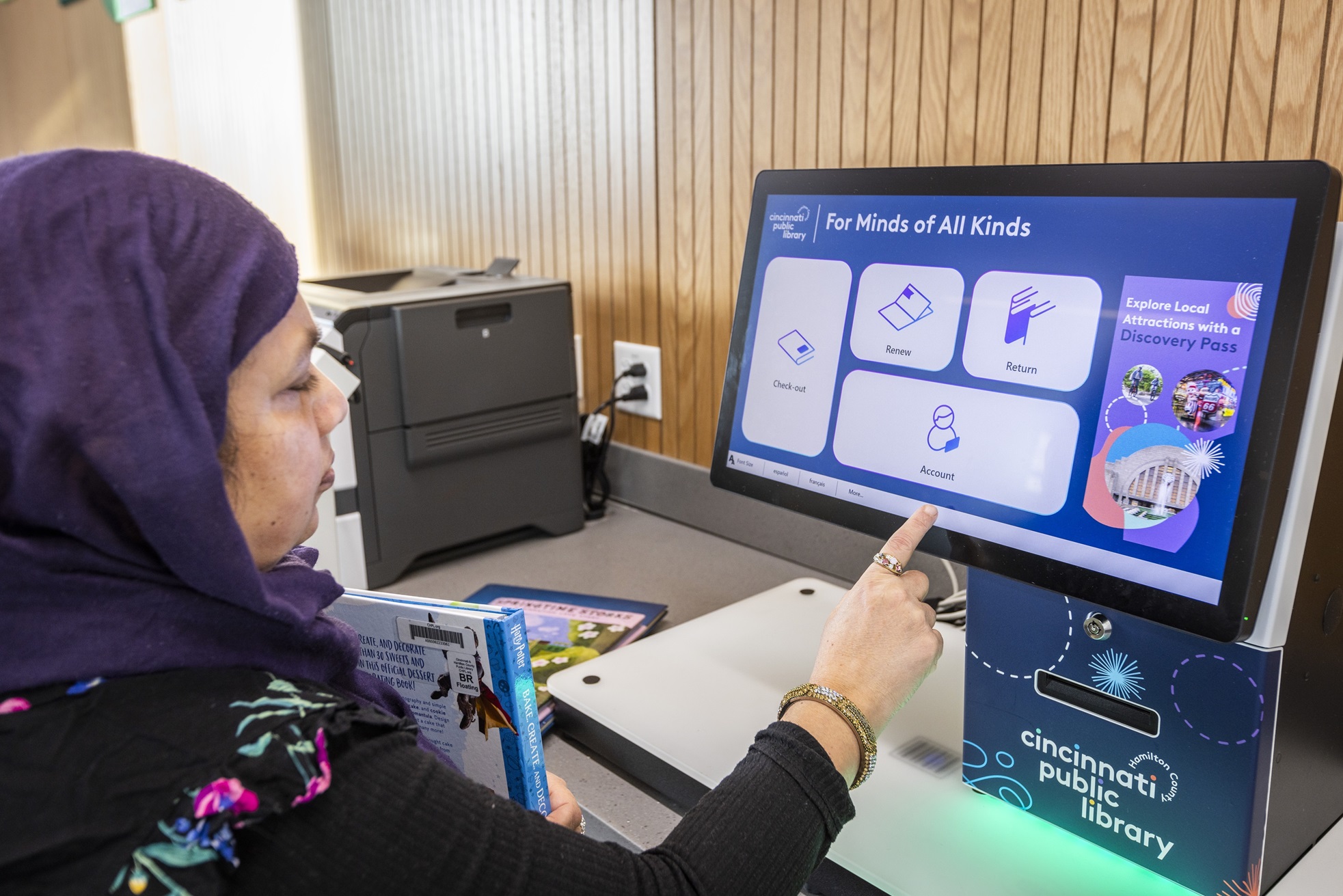 A library patron using the selfCheck 3000 kiosk at Cincinnati & Hamilton County Public Library for a seamless self-service checkout experience.